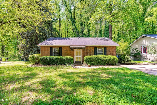 7313 Longstreet Dr, Raleigh, NC 27615 - ranch-style home with a front lawn, brick siding, and a view of trees