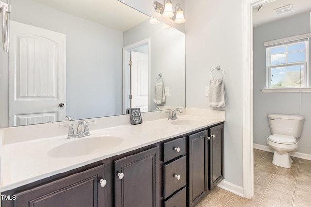 bathroom featuring tile patterned flooring, a sink, visible vents, and double vanity