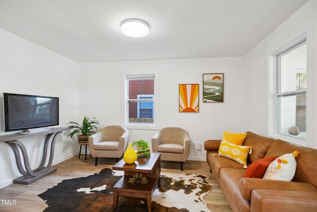 living area featuring light wood-style flooring and baseboards