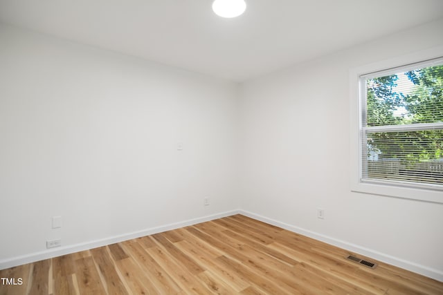 empty room with baseboards and light wood-style flooring
