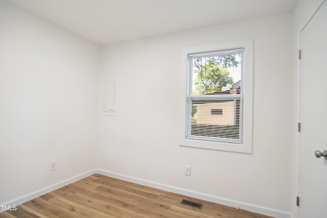 unfurnished room with baseboards and light wood-style floors
