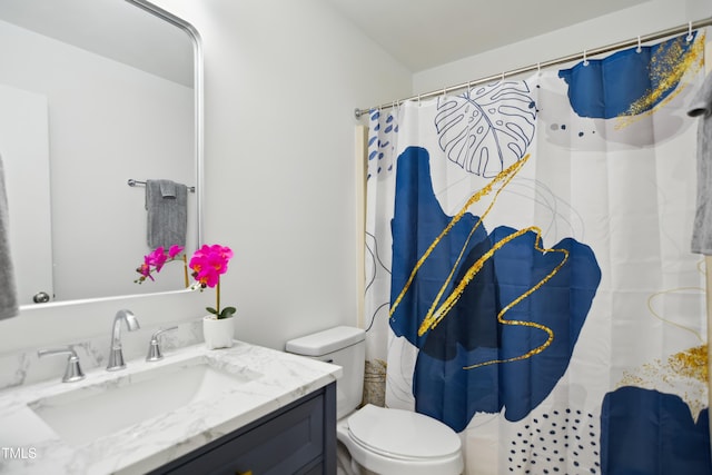 bathroom with toilet, vanity, and a shower with shower curtain
