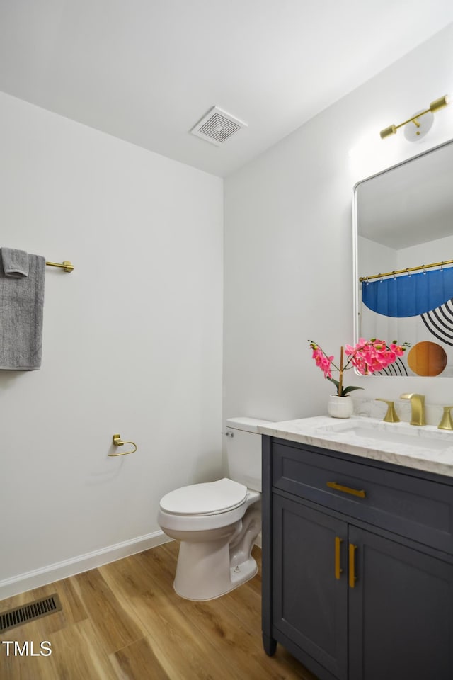 full bathroom with wood finished floors, vanity, and toilet