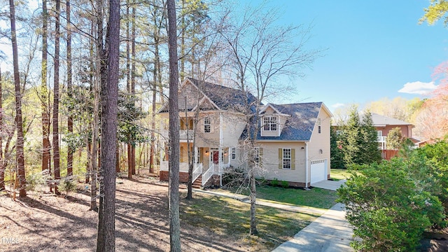 view of front of house featuring concrete driveway, an attached garage, and a front yard
