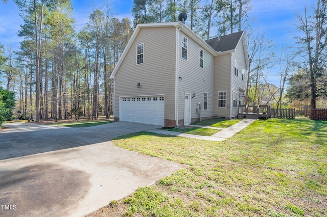view of side of property featuring a wooden deck, a lawn, concrete driveway, an attached garage, and fence