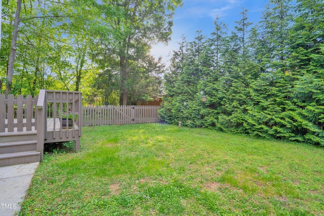 view of yard with a deck and fence