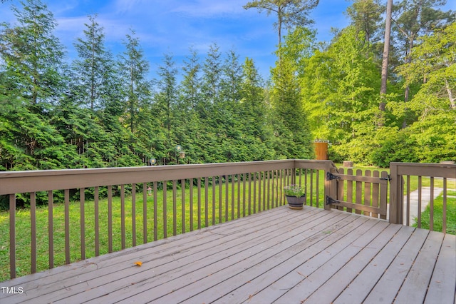 wooden deck featuring a wooded view and a yard