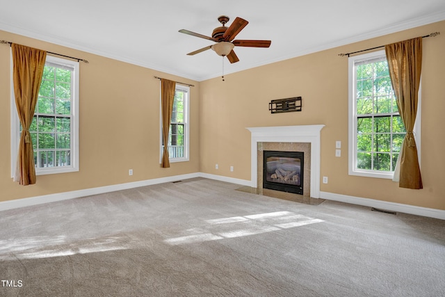 unfurnished living room featuring crown molding, a wealth of natural light, and baseboards