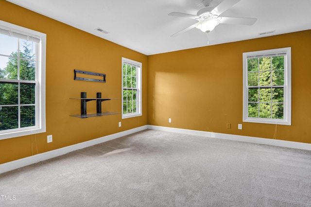 unfurnished room featuring a ceiling fan, visible vents, and plenty of natural light