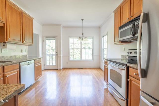 kitchen with stainless steel appliances, light wood-type flooring, decorative light fixtures, baseboards, and ornamental molding