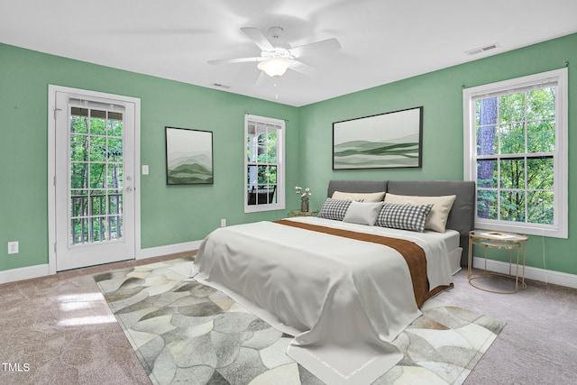 carpeted bedroom with visible vents, access to outside, and multiple windows
