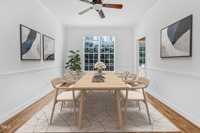 dining room with ornamental molding, a ceiling fan, light wood finished floors, and baseboards