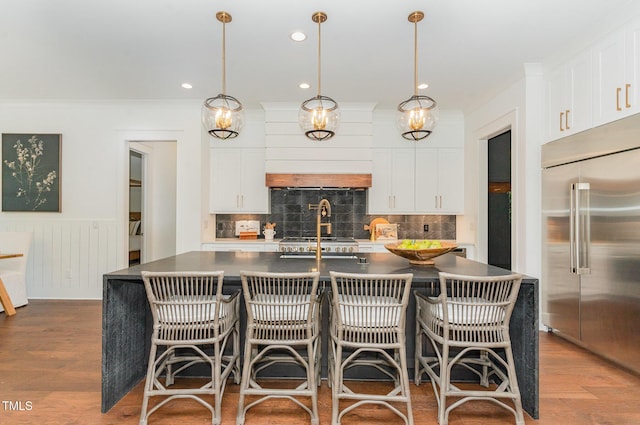 kitchen with white cabinetry, stainless steel built in fridge, and dark countertops