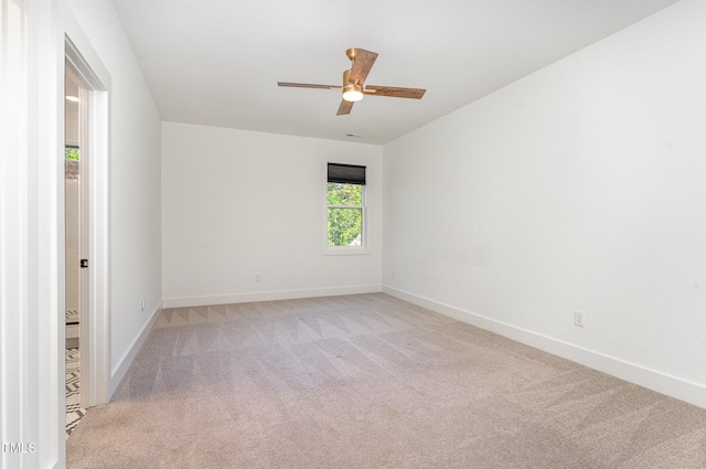 empty room with baseboards, ceiling fan, and light colored carpet