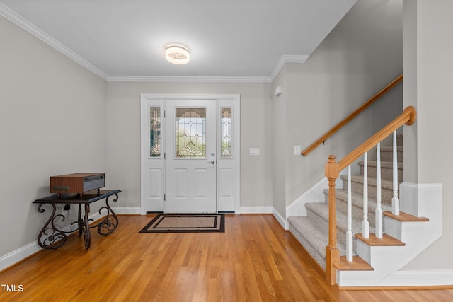 entrance foyer featuring baseboards, ornamental molding, wood finished floors, and stairway