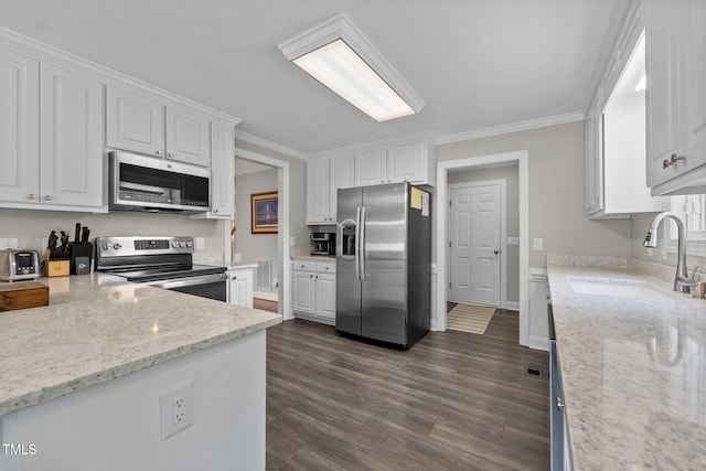 kitchen featuring dark wood-style flooring, light stone counters, a sink, stainless steel appliances, and white cabinetry