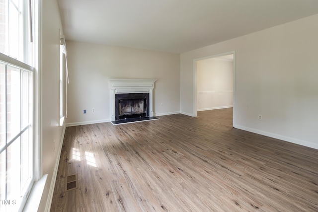 805 Penncross Dr, Raleigh, NC 27610 - unfurnished living room featuring wood finished floors, a fireplace, and baseboards