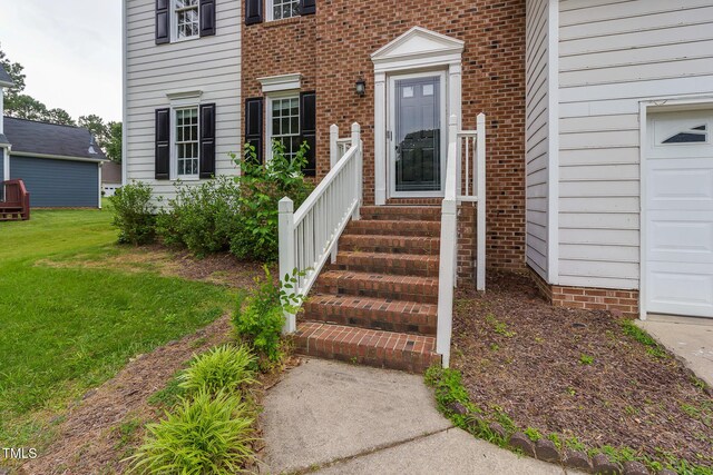 805 Penncross Dr, Raleigh, NC 27610 - view of exterior entry featuring a garage and a lawn