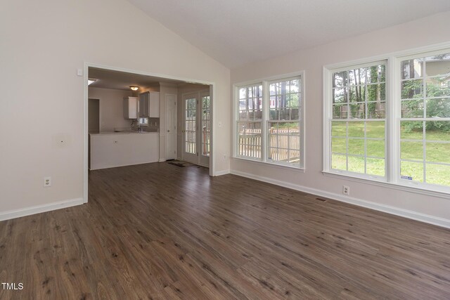 805 Penncross Dr, Raleigh, NC 27610 - unfurnished living room with lofted ceiling, dark wood-style floors, and baseboards