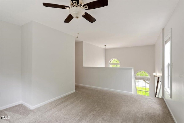carpeted empty room with baseboards and ceiling fan