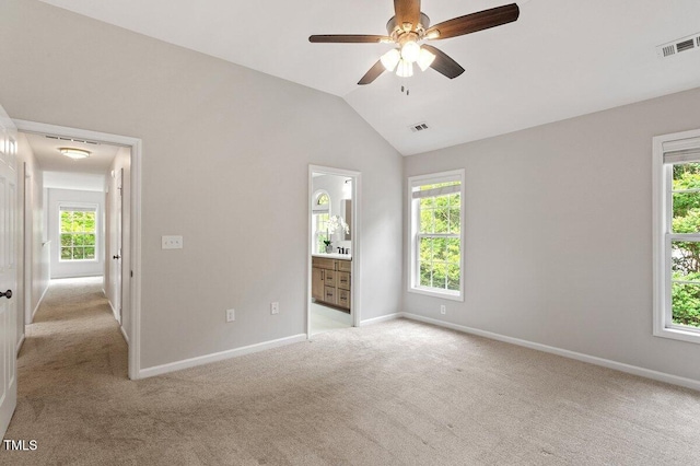unfurnished bedroom with baseboards, light colored carpet, lofted ceiling, and visible vents