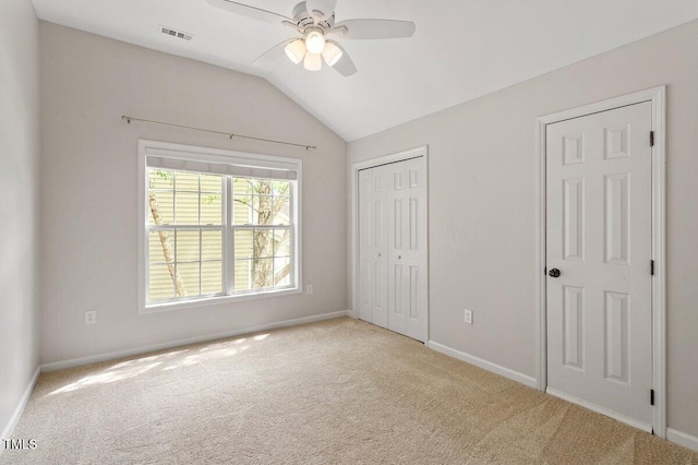 unfurnished bedroom featuring carpet flooring, visible vents, and vaulted ceiling