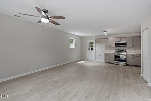 unfurnished living room featuring baseboards, a ceiling fan, visible vents, and light wood-style flooring