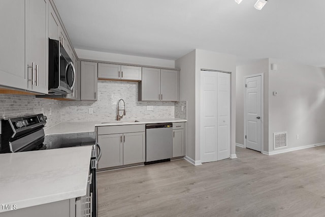 kitchen with visible vents, stainless steel appliances, gray cabinetry, and a sink