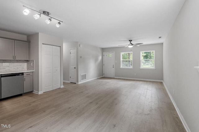 unfurnished living room featuring light wood finished floors, baseboards, visible vents, and ceiling fan