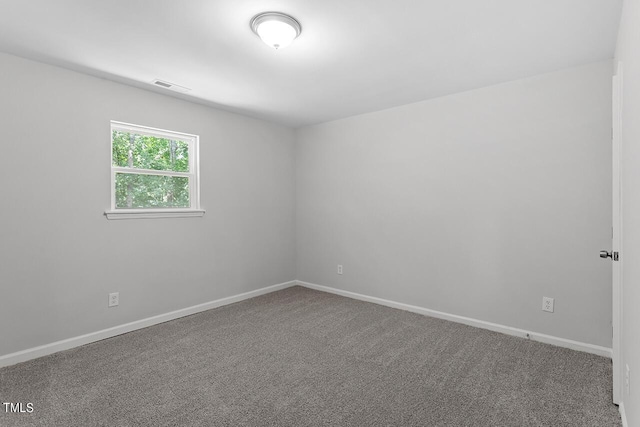 spare room featuring baseboards, visible vents, and carpet