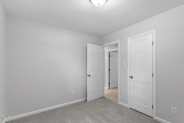 unfurnished bedroom with carpet flooring and baseboards
