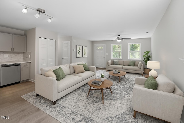 living room with light wood-style floors and a ceiling fan