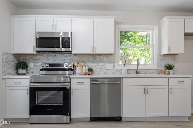 kitchen featuring appliances with stainless steel finishes, white cabinetry, and light countertops