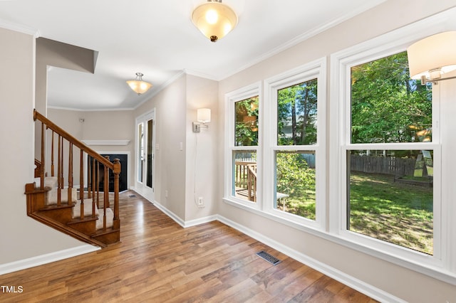 entrance foyer featuring visible vents, wood finished floors, a wealth of natural light, and stairway