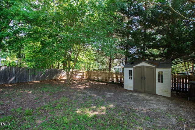 view of yard with a storage shed, an outdoor structure, and a fenced backyard