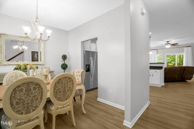1305 Montreux Ct, Mebane, NC 27302 - dining area with light wood-style floors, ceiling fan with notable chandelier, and baseboards
