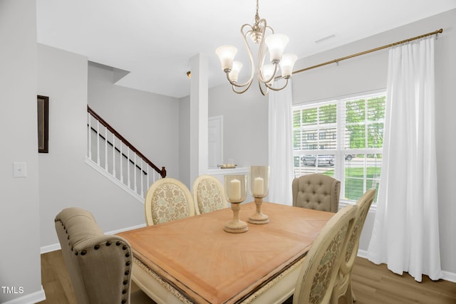 1305 Montreux Ct, Mebane, NC 27302 - dining space featuring stairway, visible vents, a chandelier, baseboards, and wood finished floors