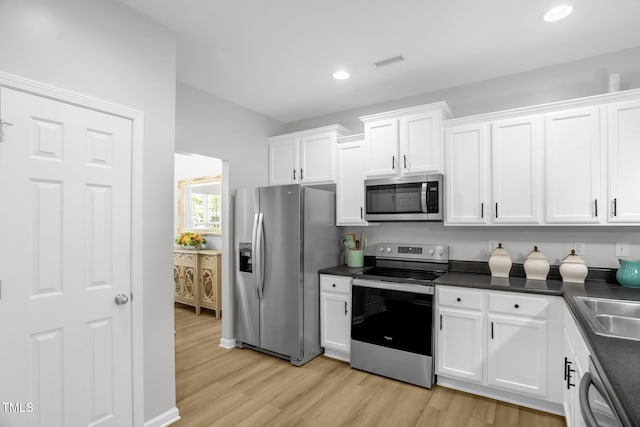 1305 Montreux Ct, Mebane, NC 27302 - kitchen with visible vents, white cabinets, dark countertops, and appliances with stainless steel finishes