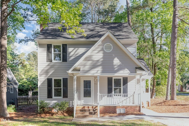 view of front of house with covered porch, fence, a chimney, and a shingled roof