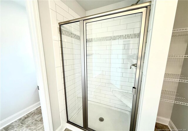 full bathroom with baseboards and a stall shower