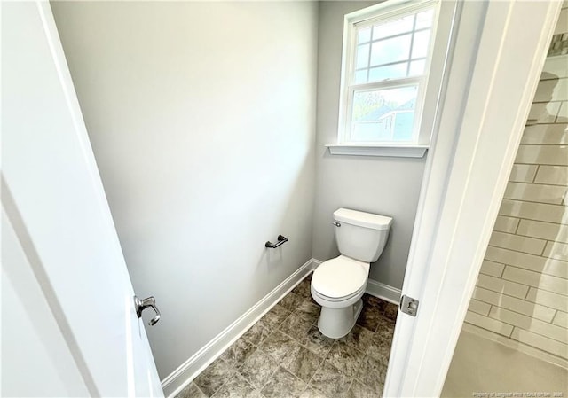 bathroom with toilet and baseboards