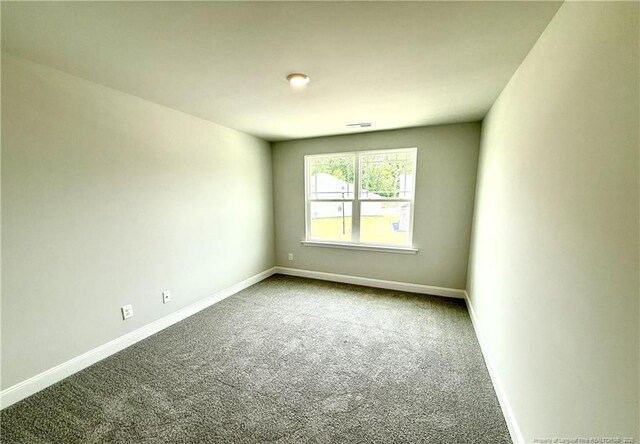 carpeted spare room with baseboards and visible vents
