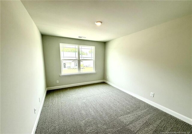 carpeted spare room featuring visible vents and baseboards