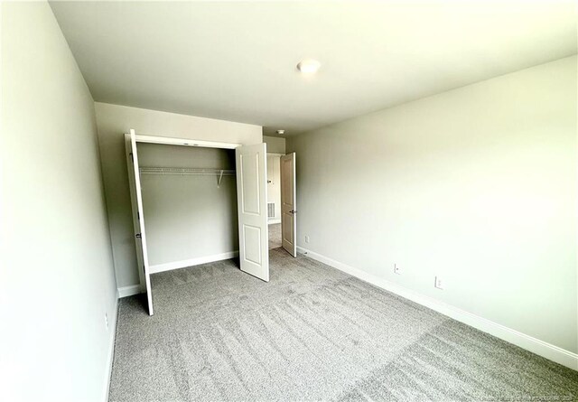 unfurnished bedroom with a closet, baseboards, and carpet floors