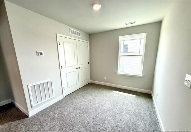 unfurnished bedroom featuring visible vents, carpet floors, and baseboards