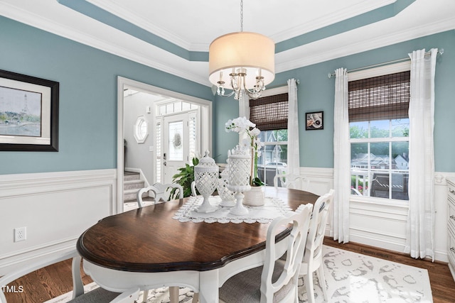 48 Falling Oak Ct, Clayton, NC 27520 - dining space featuring wainscoting, wood finished floors, crown molding, a chandelier, and a decorative wall