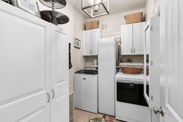 48 Falling Oak Ct, Clayton, NC 27520 - laundry room with cabinet space, light tile patterned floors, and washing machine and clothes dryer