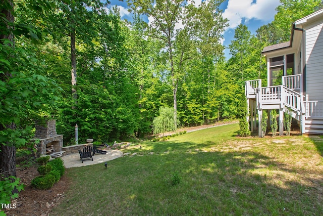 197 Boxwood Dr, Pittsboro, NC 27312 - view of green lawn with stairway, an outdoor stone fireplace, a patio area, and a wooden deck