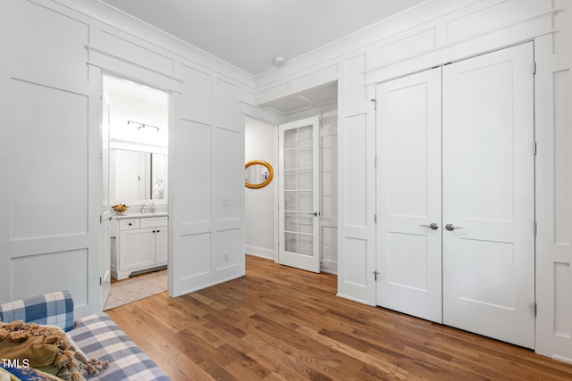 197 Boxwood Dr, Pittsboro, NC 27312 - bedroom featuring wood finished floors, ensuite bath, a closet, crown molding, and a sink