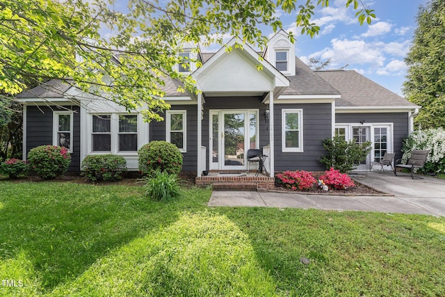 view of front of home featuring a shingled roof and a front yard